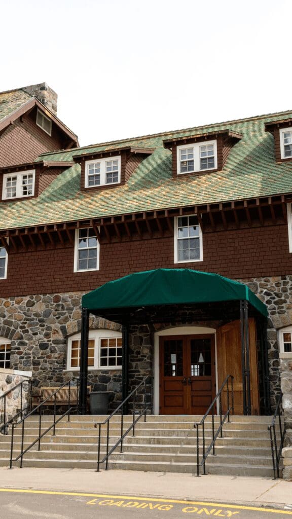 brown wooden and rock lodge with green roof