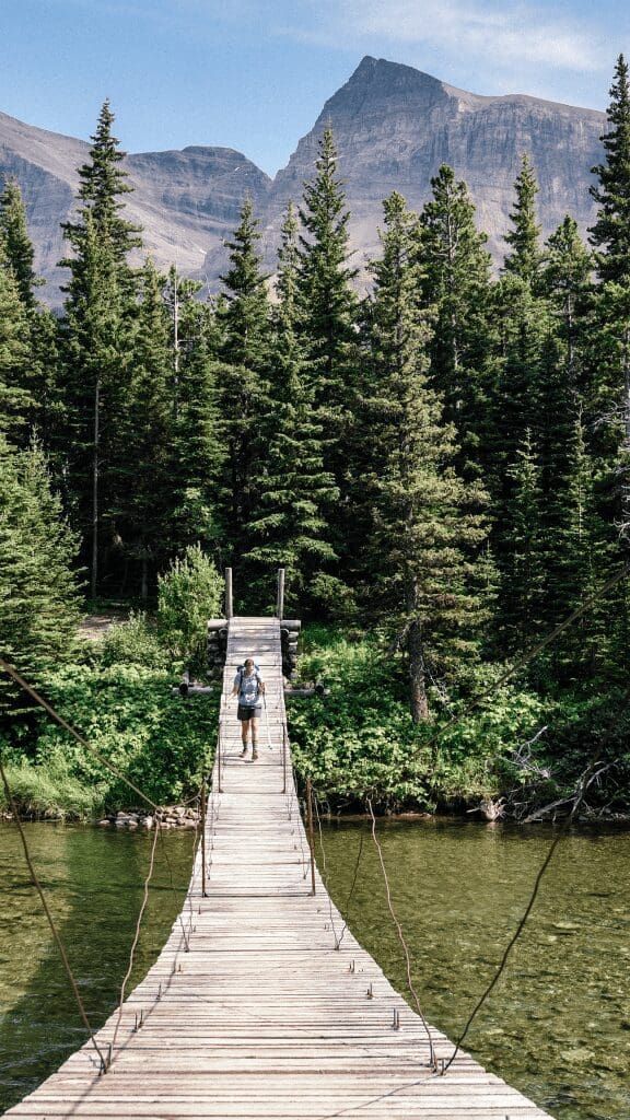 wooden pier at glacier national park with woman walking