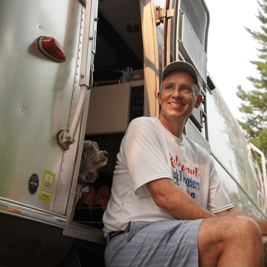 John sitting with Annie on the steps of the Airstream