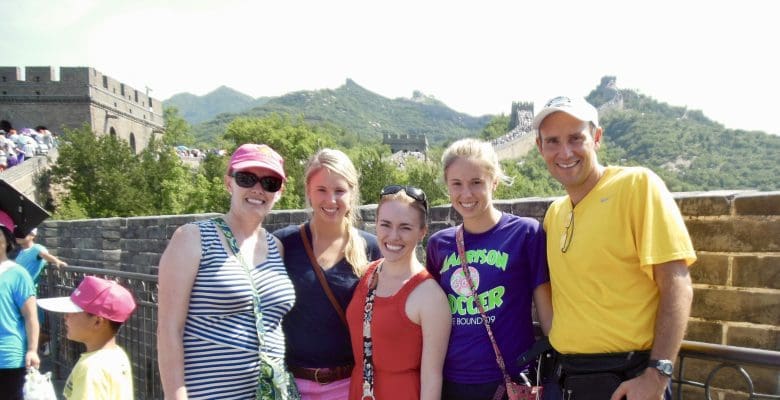 five people posing at great wall looking happy on a sunny day