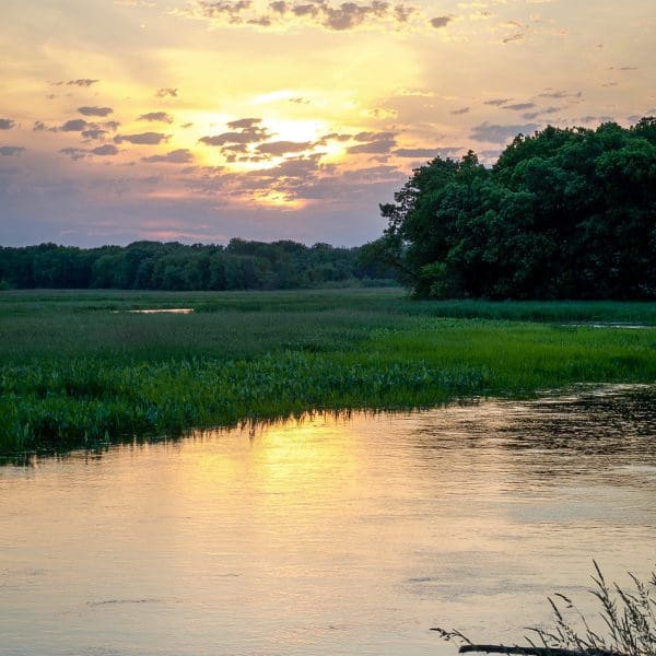 view of river flowing through Perrot State Park at sunset