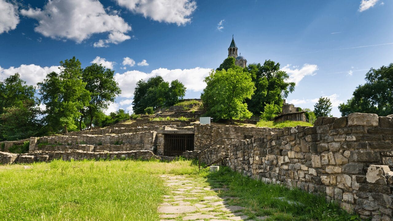 pathway through green grass and rock walls