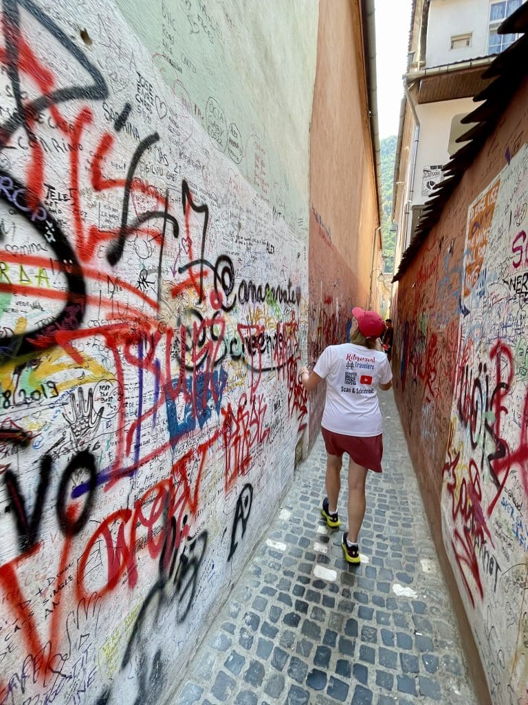 bev walking through the narrow street looking at the writing on the walls