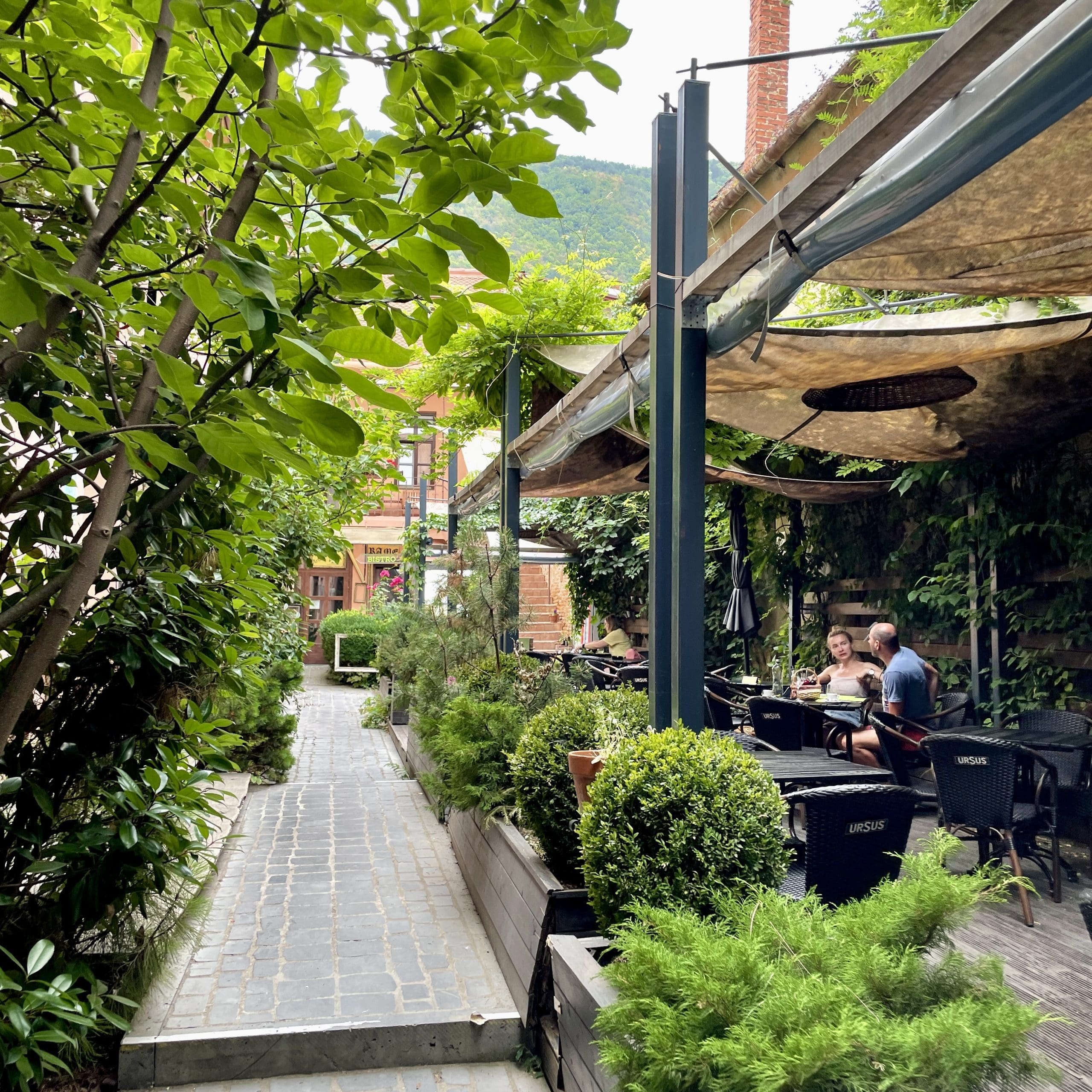 a walkway with tables to the side for dining