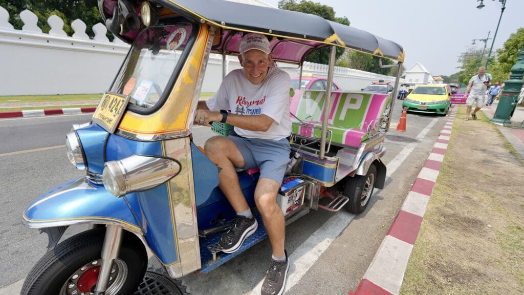 man riding in a long tuk tuk