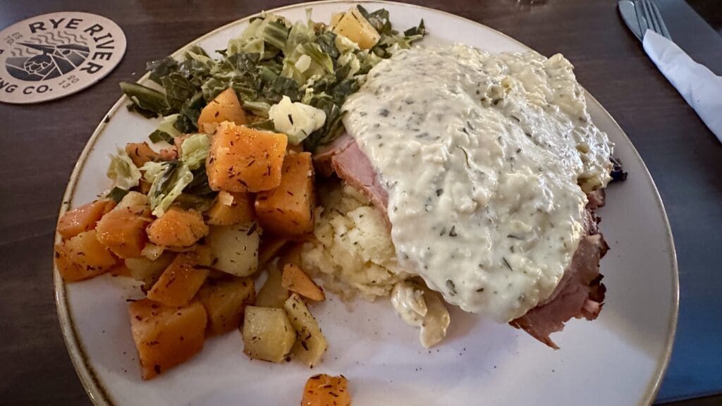 Irish meal on a plate with bacon, gravy, and cabbage