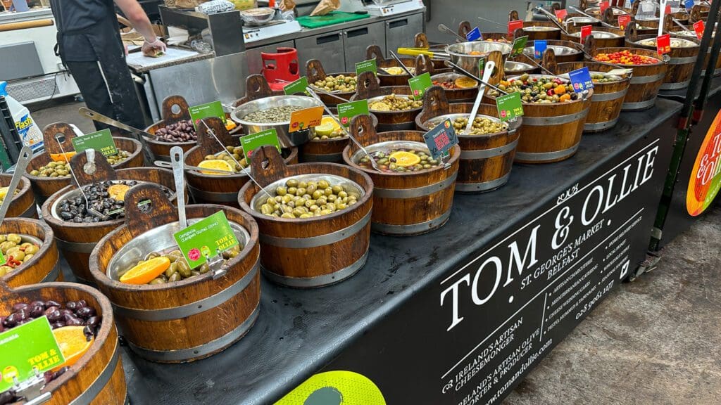 store with many small barrels of olives at St. Georges market in Belfast