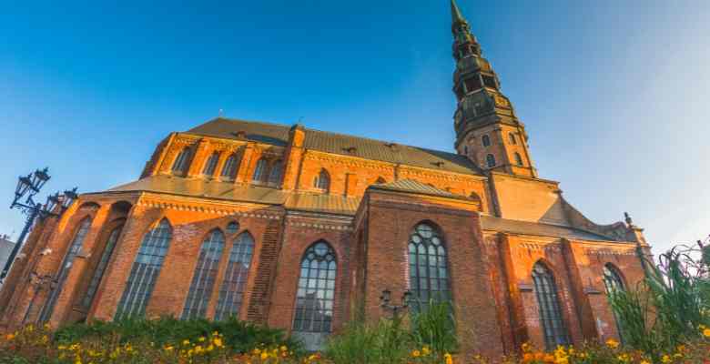 A Gothic church that is brick and redish orange.