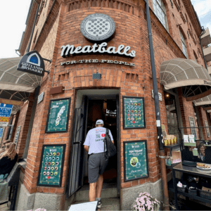 Man walking through the entrance of a brick building restaurant