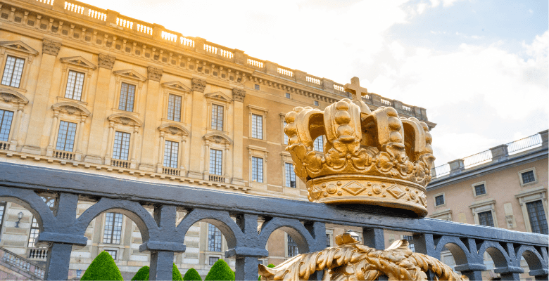 Exterior view of the Stockholm Royal Palace with golden crown in foreground