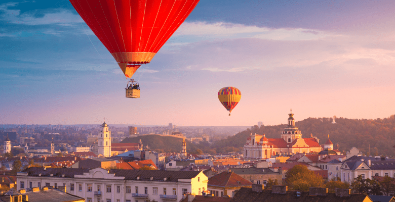 hot air balloons flying over a city landscape in Vilnius