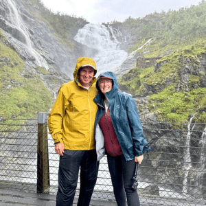 John and Bev in front of a waterfall in Norway