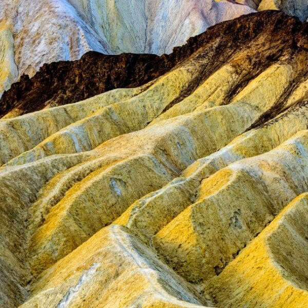 colorful yellow rock formations in death valley